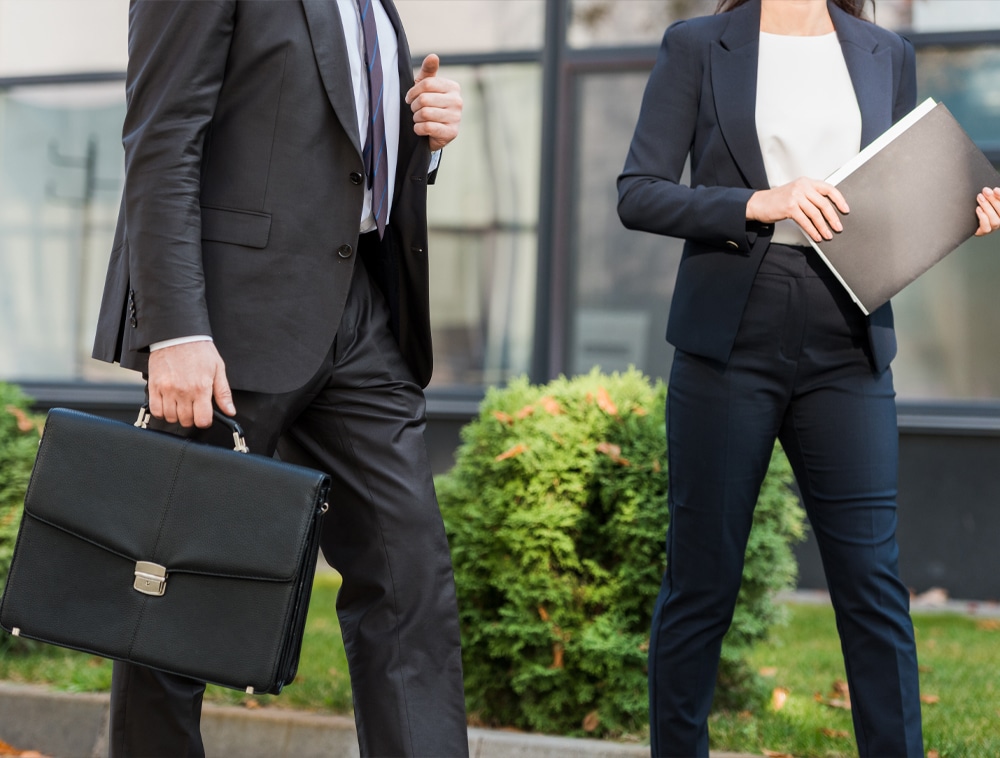 a man wearing a suit and tie standing next to a woman