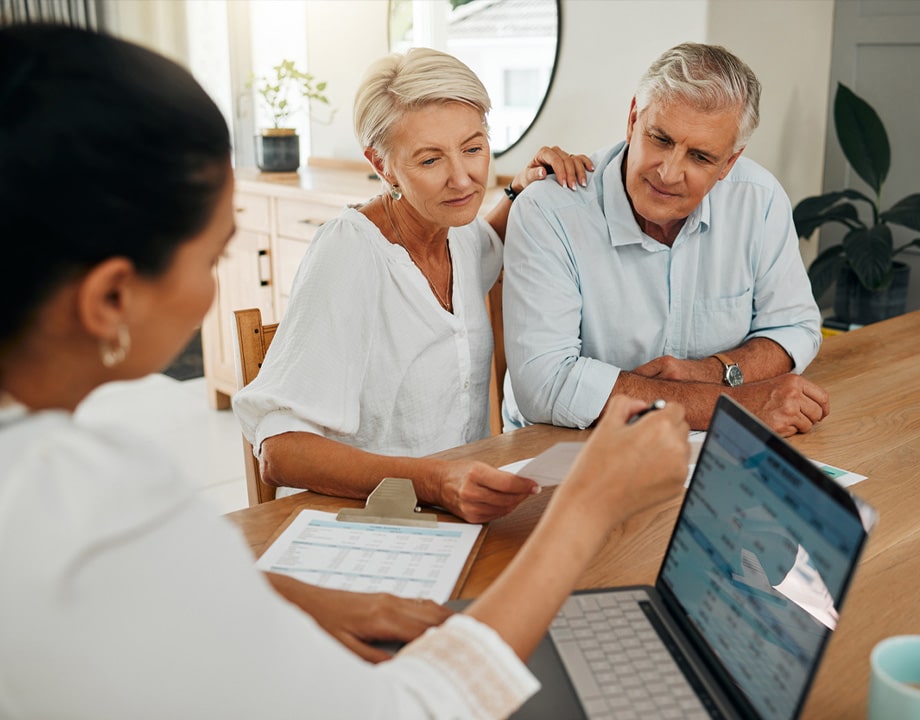 a group of people sitting at a table using a laptop